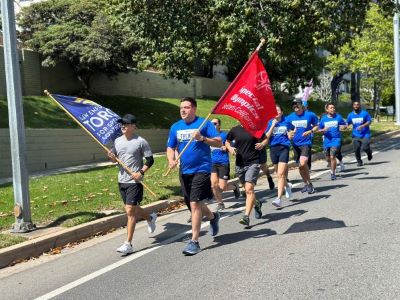 UCPD personnel running with the torch and Special Olympics flags