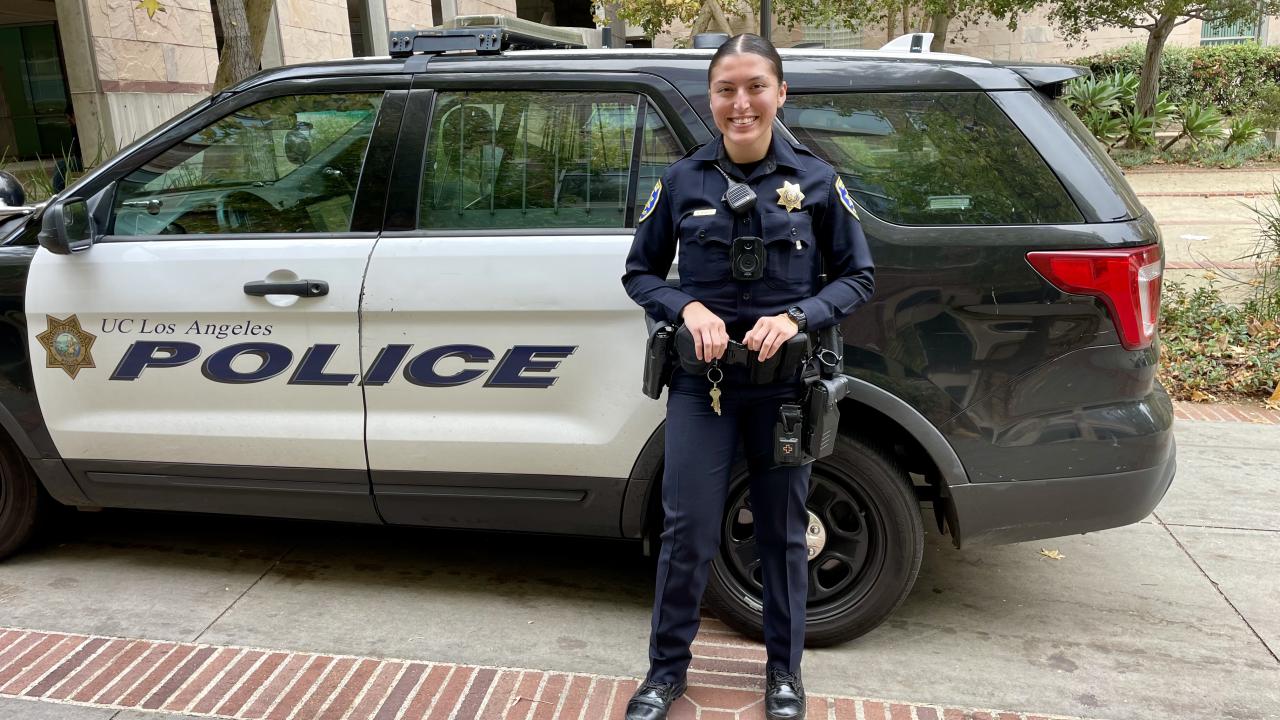 Officer Melody Mendoza standing in front of a UCPD vehicle